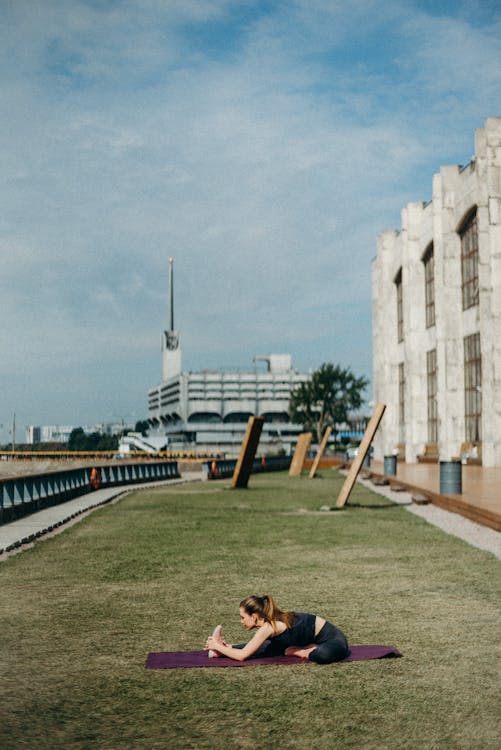 Woman Doing Yoga Pose on Grass Field