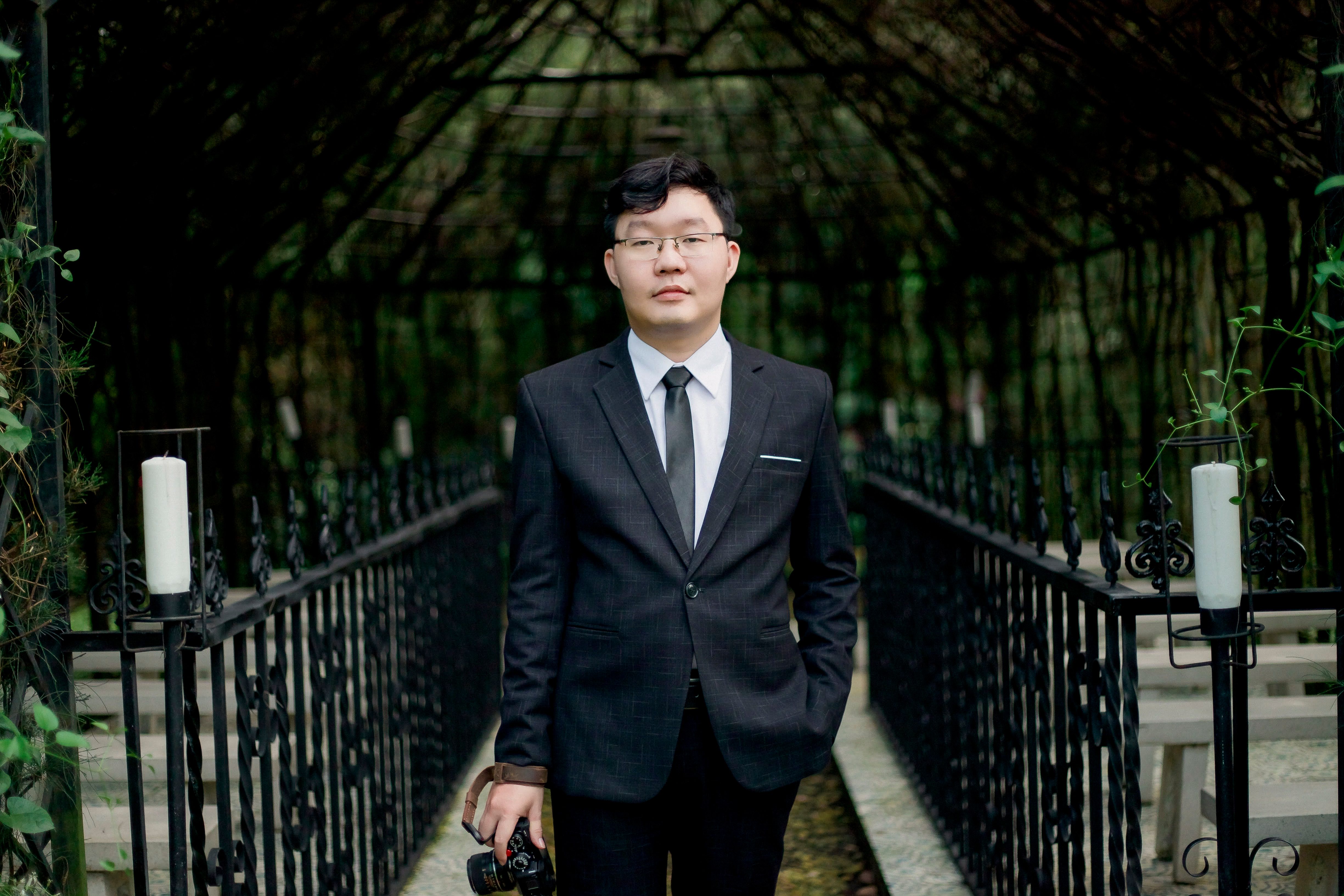 A man in a suit and tie standing in front of a gazebo · Free Stock Photo