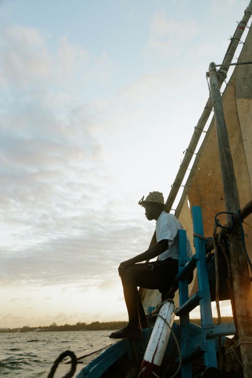 Free A man on a traditional boat at sunset in Mombasa, Kenya, capturing the essence of maritime life. Stock Photo