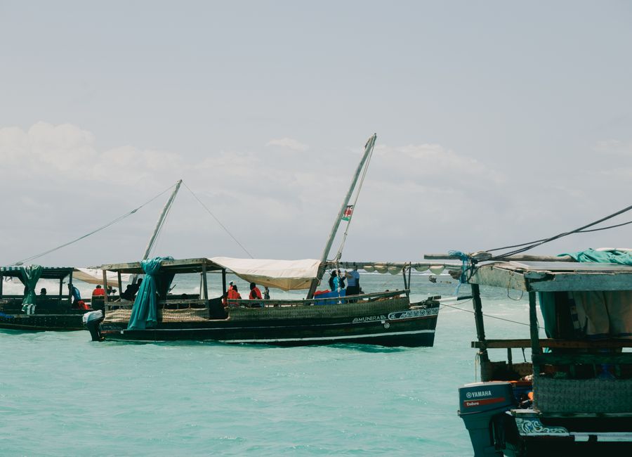 Traditional fishing boats in Mombasa harbor on a sunny day, showcasing local culture.