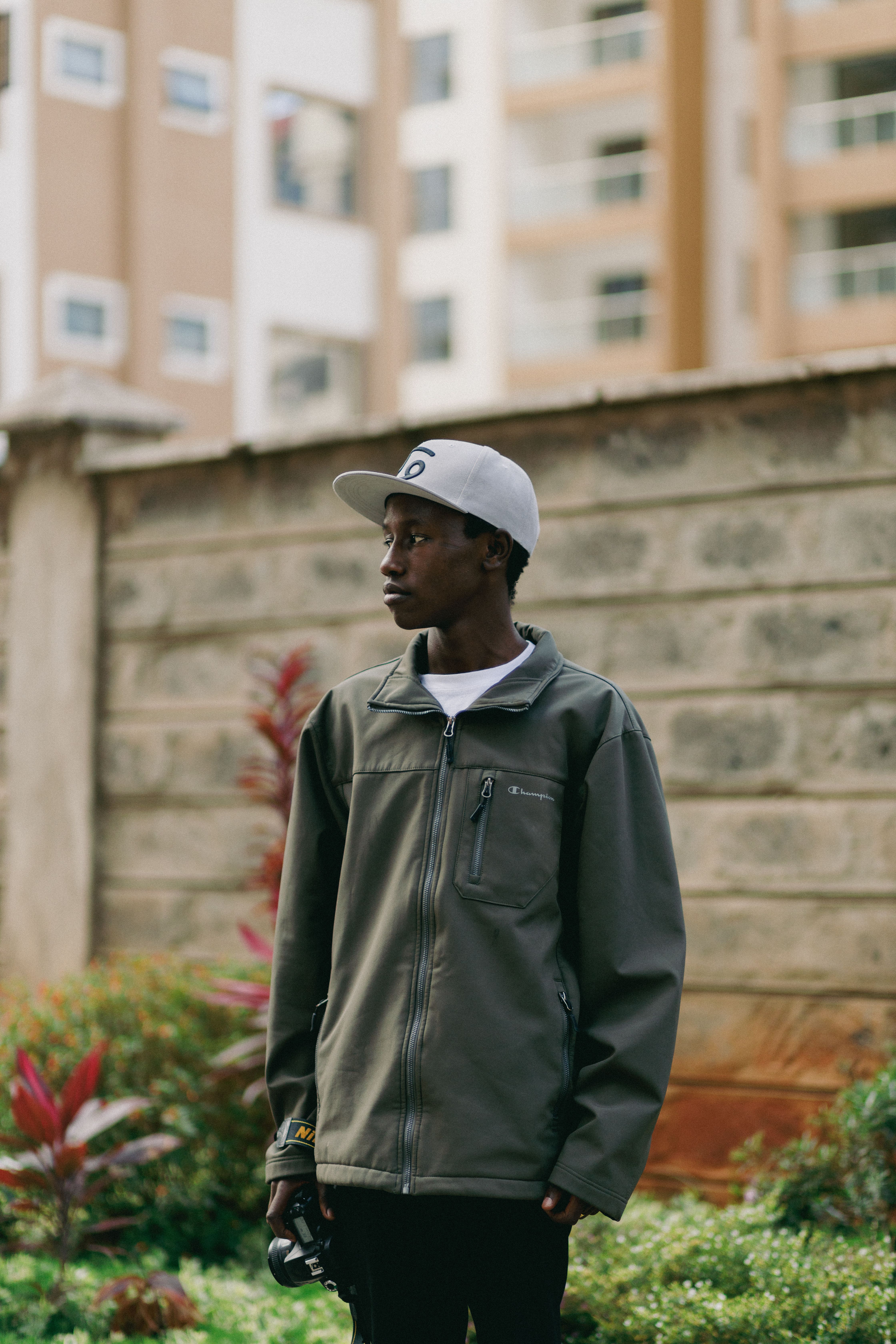 Stylish outdoor portrait of a young man in Nairobi, showing urban fashion and culture.