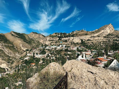 A picturesque view of a village nestled in the mountains of Dagestan, Russia, under a clear blue sky.