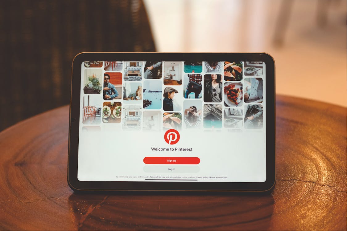 Free Tablet showing Pinterest login screen on a wooden table indoors. Stock Photo