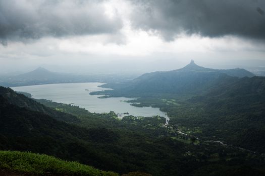 A breathtaking view of mountains and a lake under stormy clouds, capturing nature's dramatic beauty.