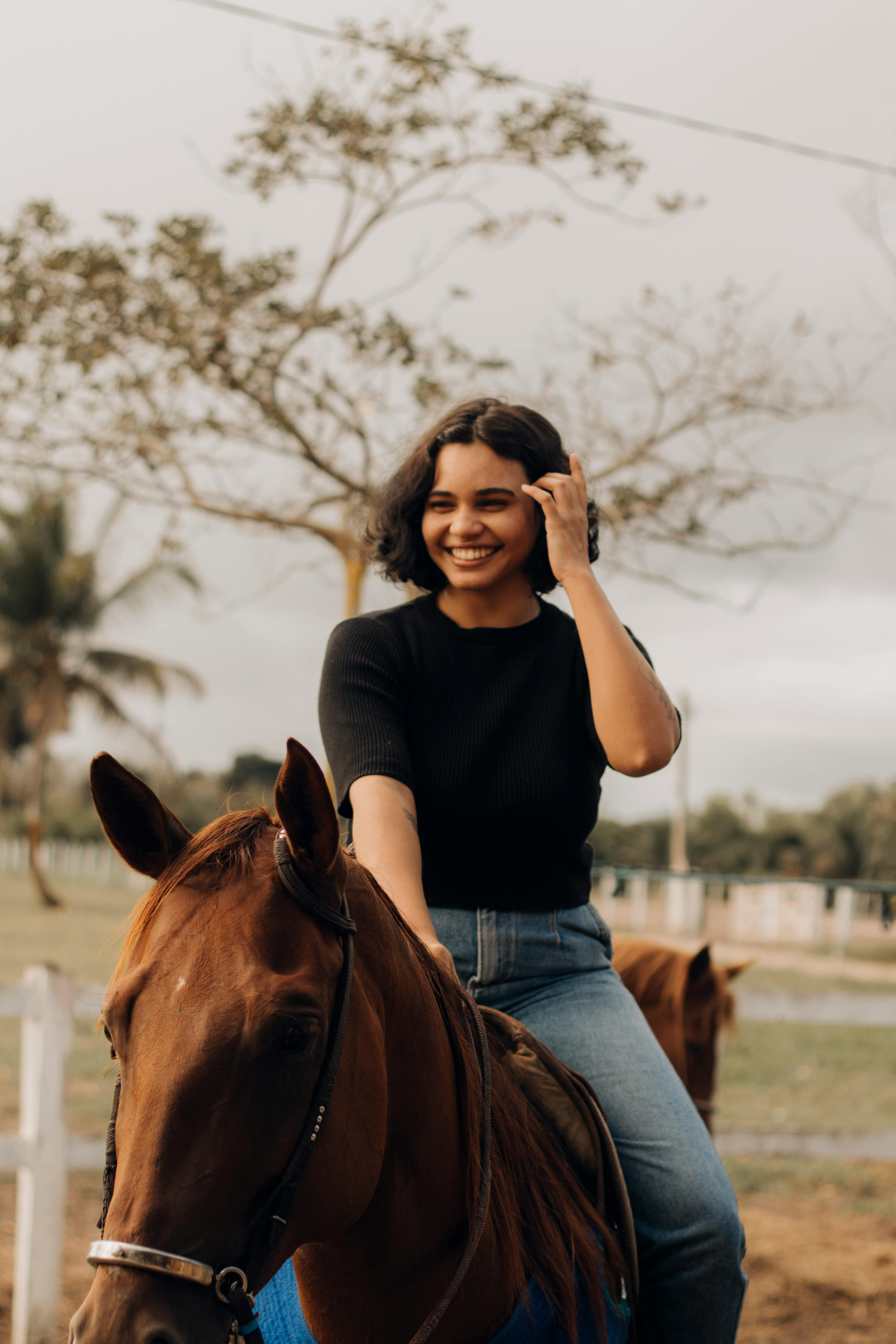 a woman riding a horse in a field