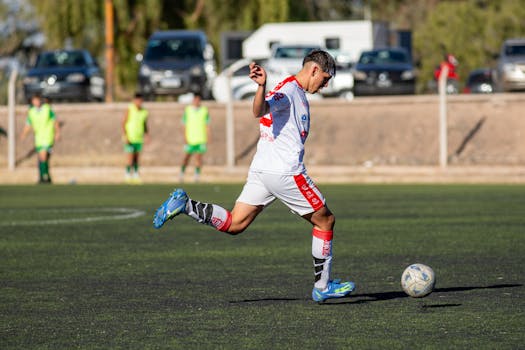 Young soccer player takes an athletic kick on an outdoor field during a match.