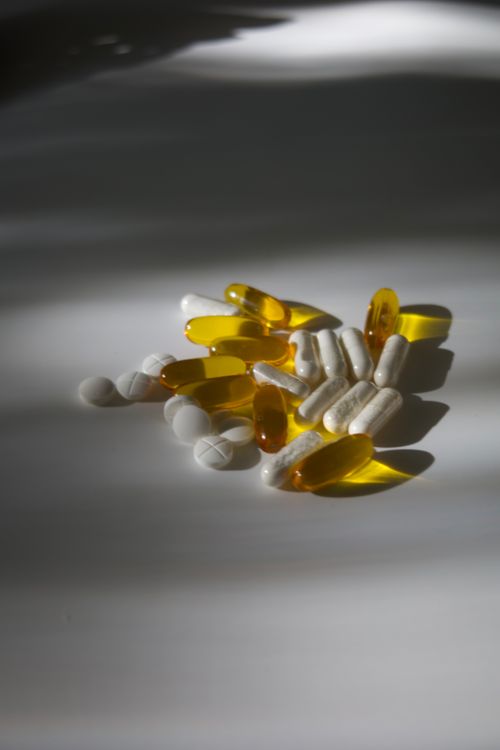 Free A still life arrangement of assorted pills on a white surface under soft light. Stock Photo