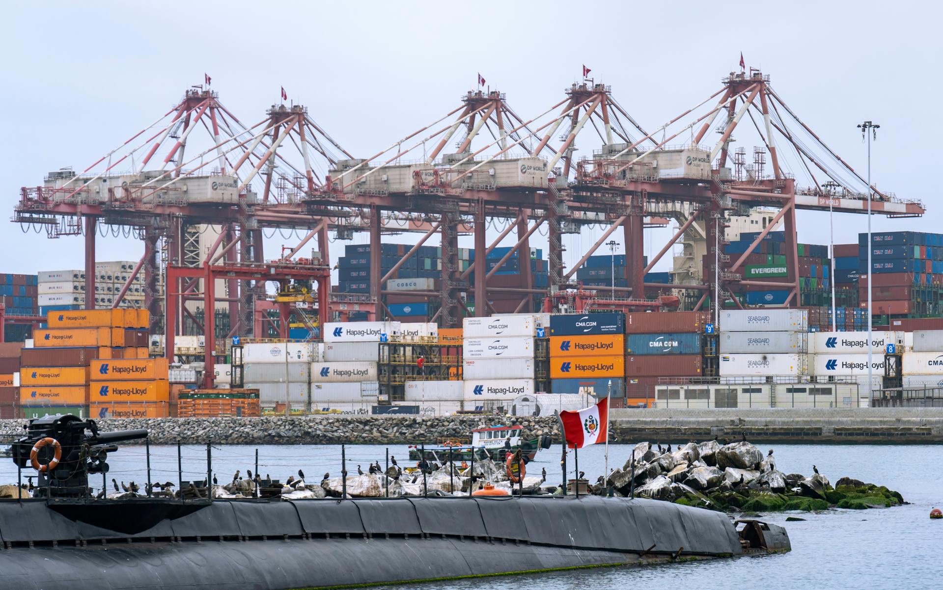 Busy cargo port in Callao, Peru featuring cranes and shipping containers.