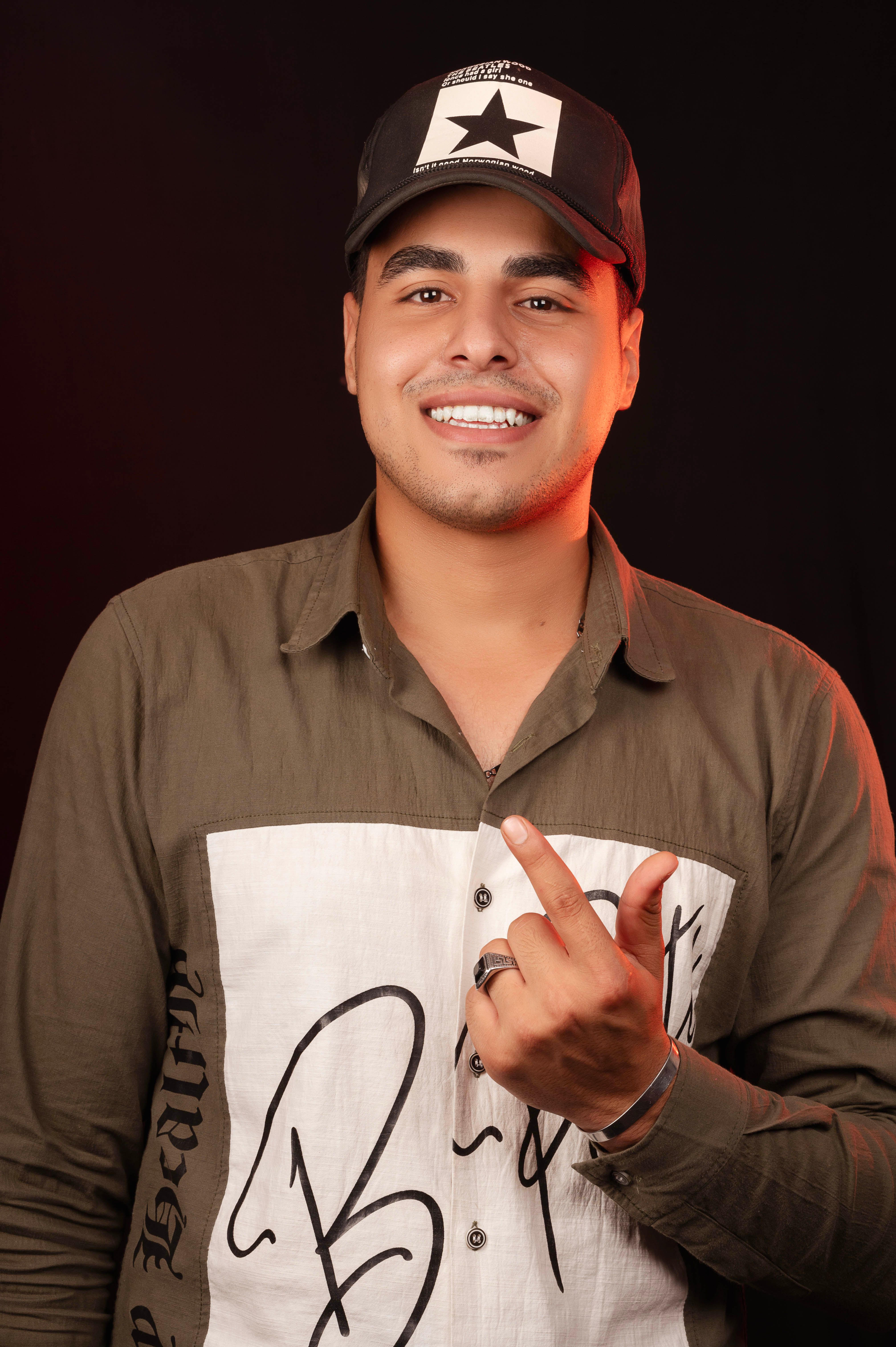 Portrait of a smiling man wearing a trendy baseball cap and casual shirt.