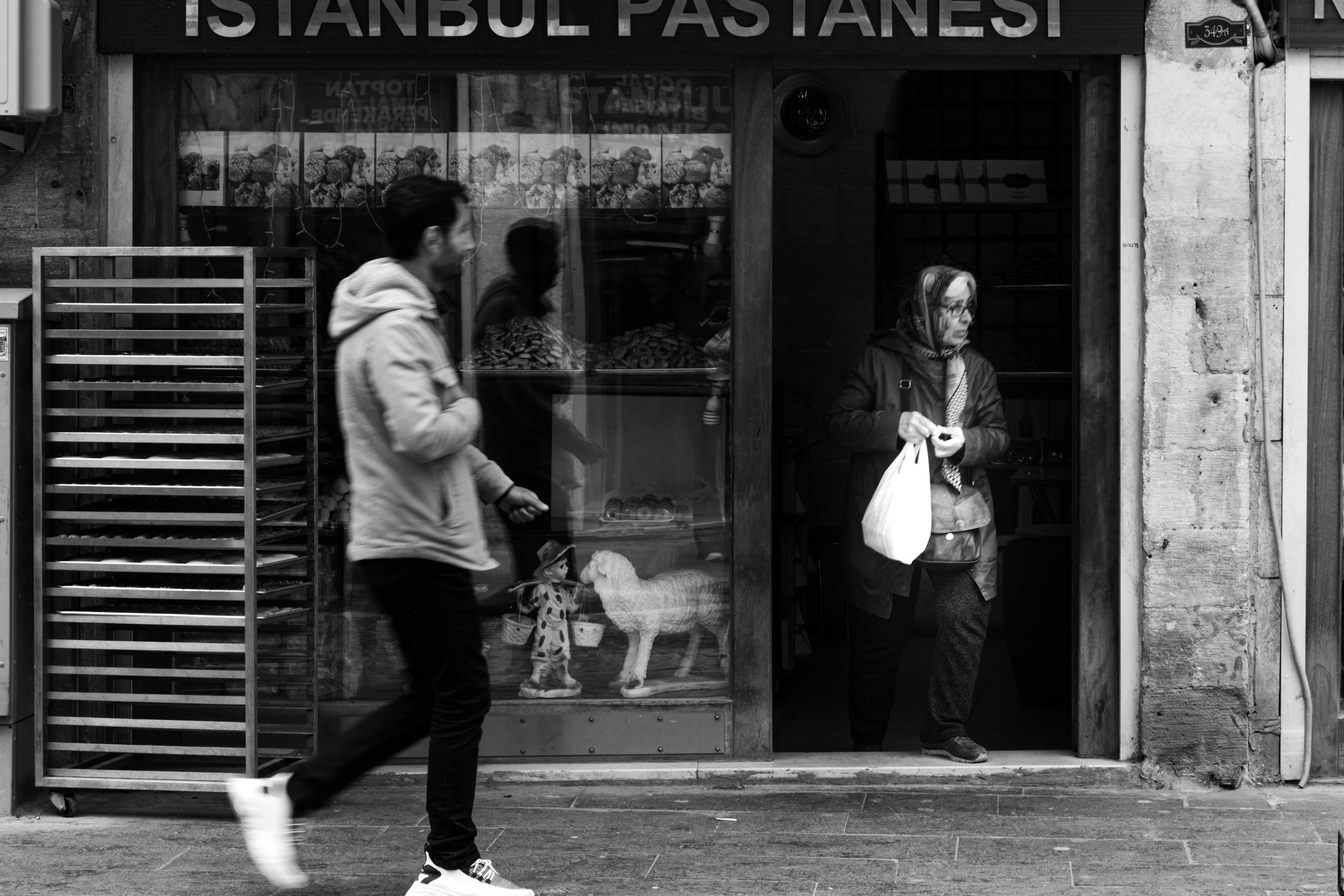 a man and woman walking past a store