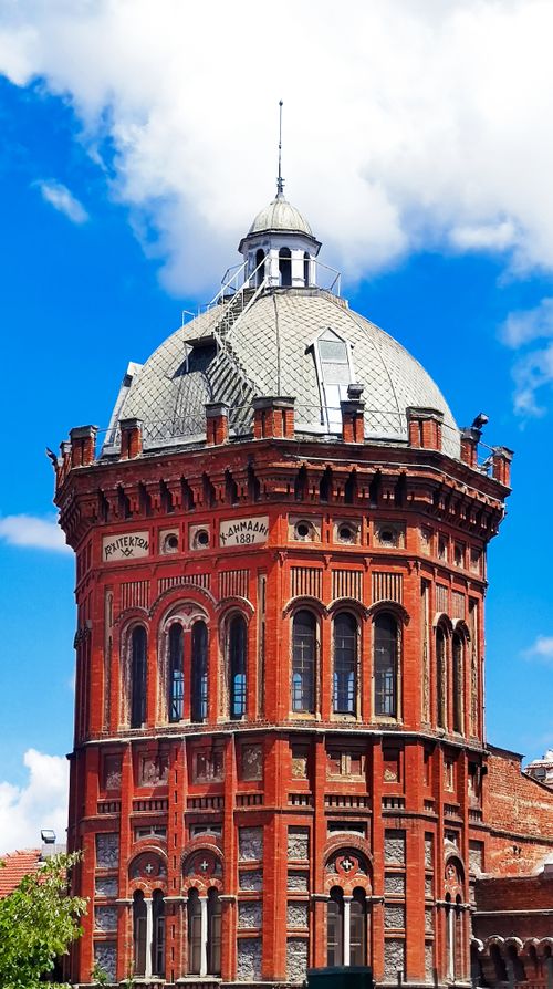 Free Stunning red brick tower with a dome against a blue sky, showcasing classic architecture. Stock Photo