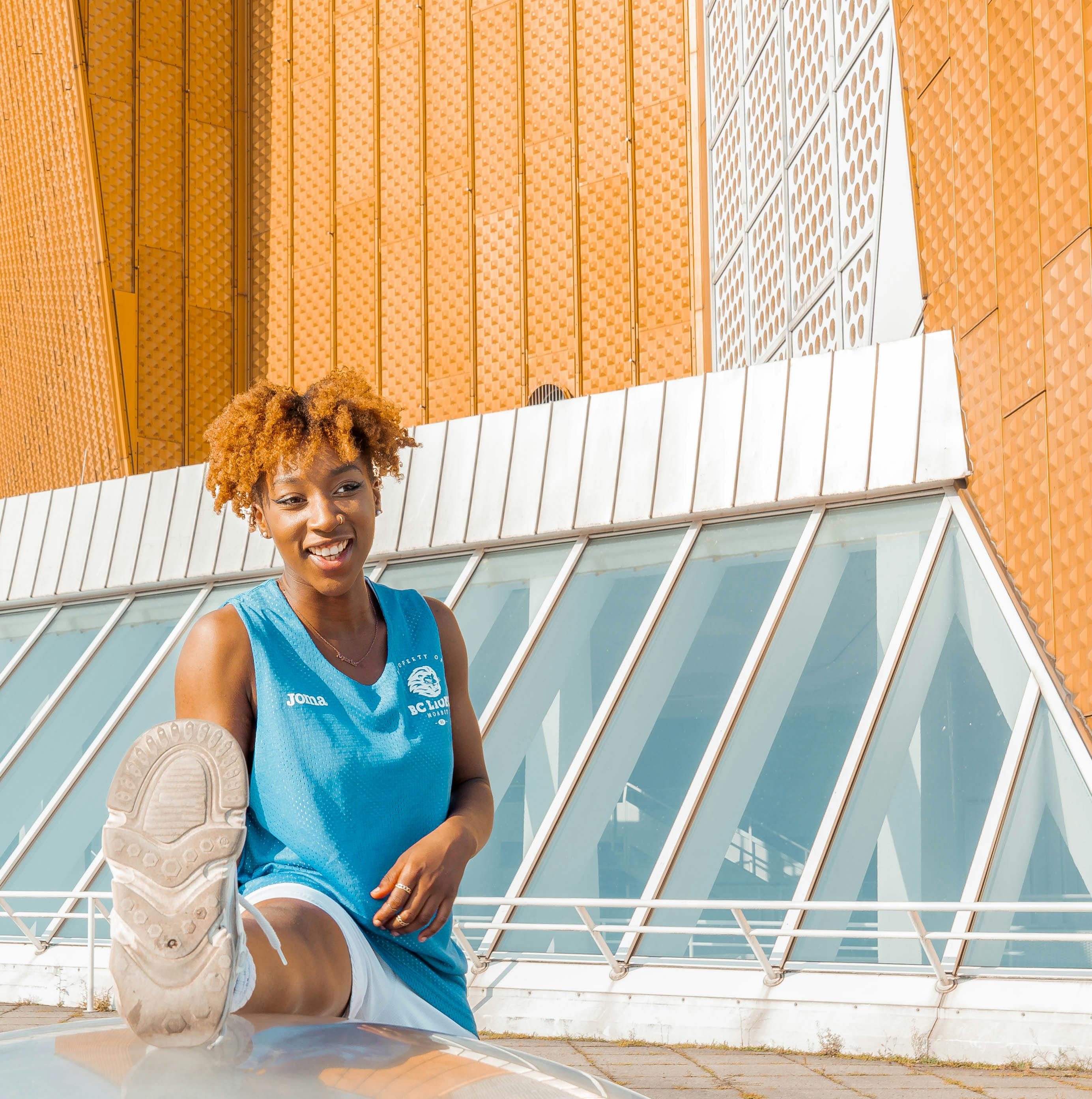 a woman in a blue shirt sitting on a skateboard