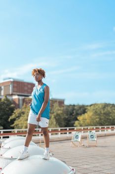 A young woman in casual attire enjoying an outdoor summer day, exuding energy and confidence.