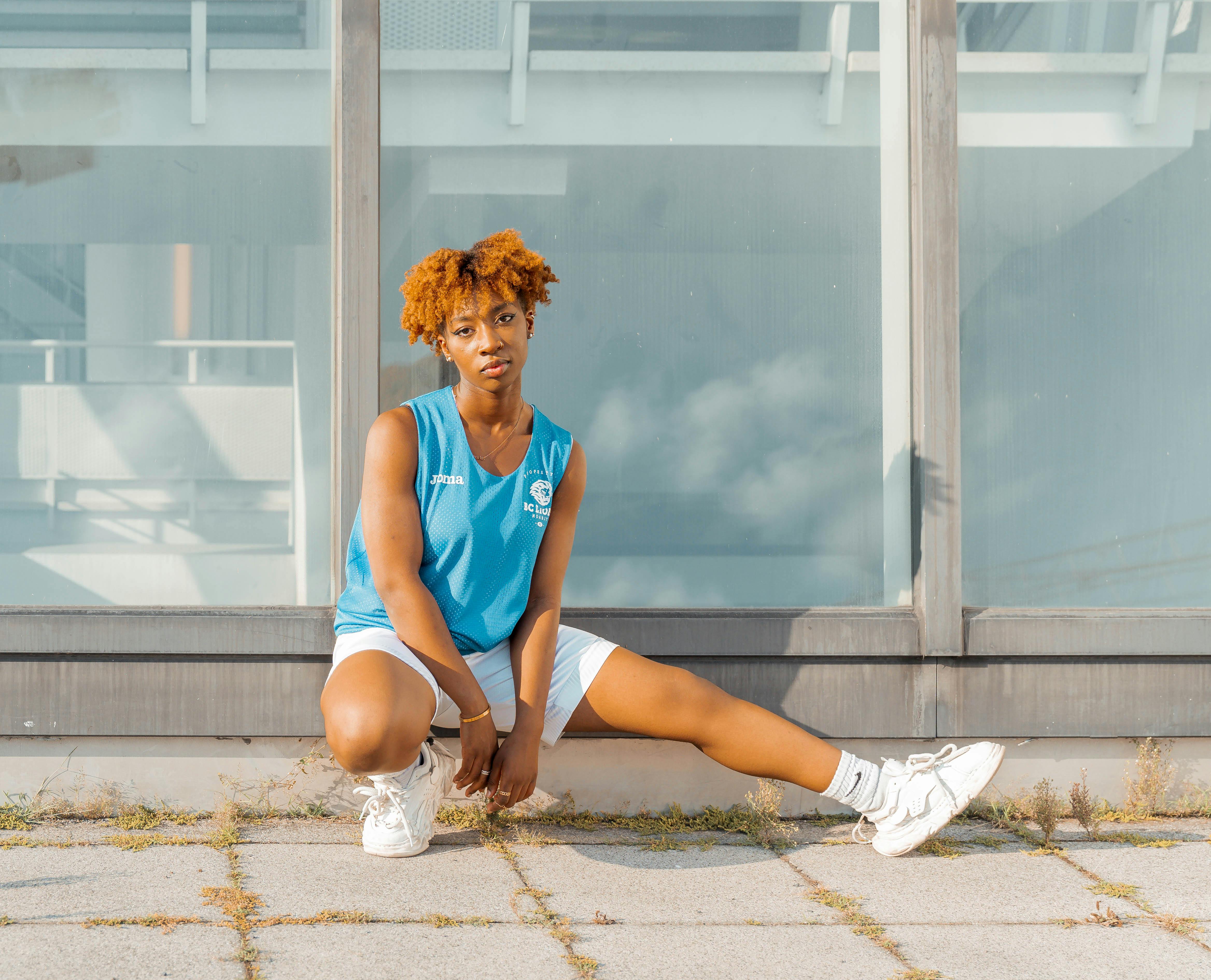 woman sitting in tank top and shorts