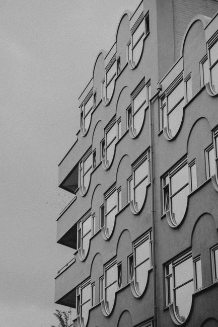 Black and white photo of a modern building showcasing a unique facade with geometric patterns.