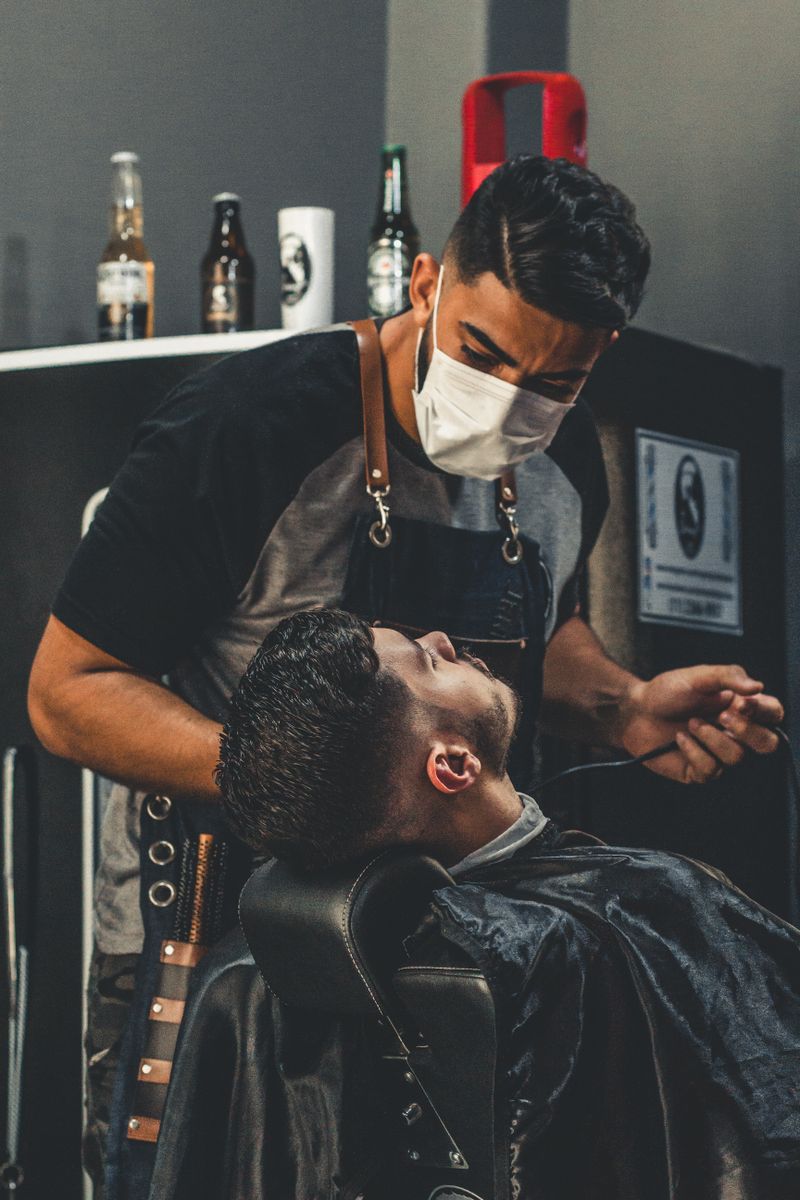 Barber trimming a client’s hair in a barber shop