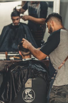 Professional barber crafting a modern hairstyle at a barbershop, reflecting style and grooming culture.