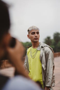 穿着明亮衣服的时尚男人在户外摆出姿势，专注于现代时尚