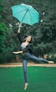 一位年轻的南亚女子在公园里撑着伞快乐地跳舞