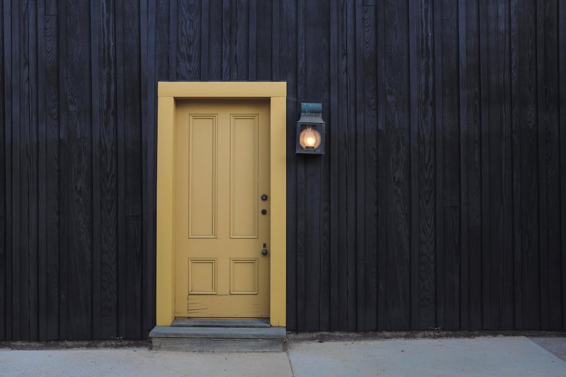Free Closed Door and Lighted Light Sconce Stock Photo