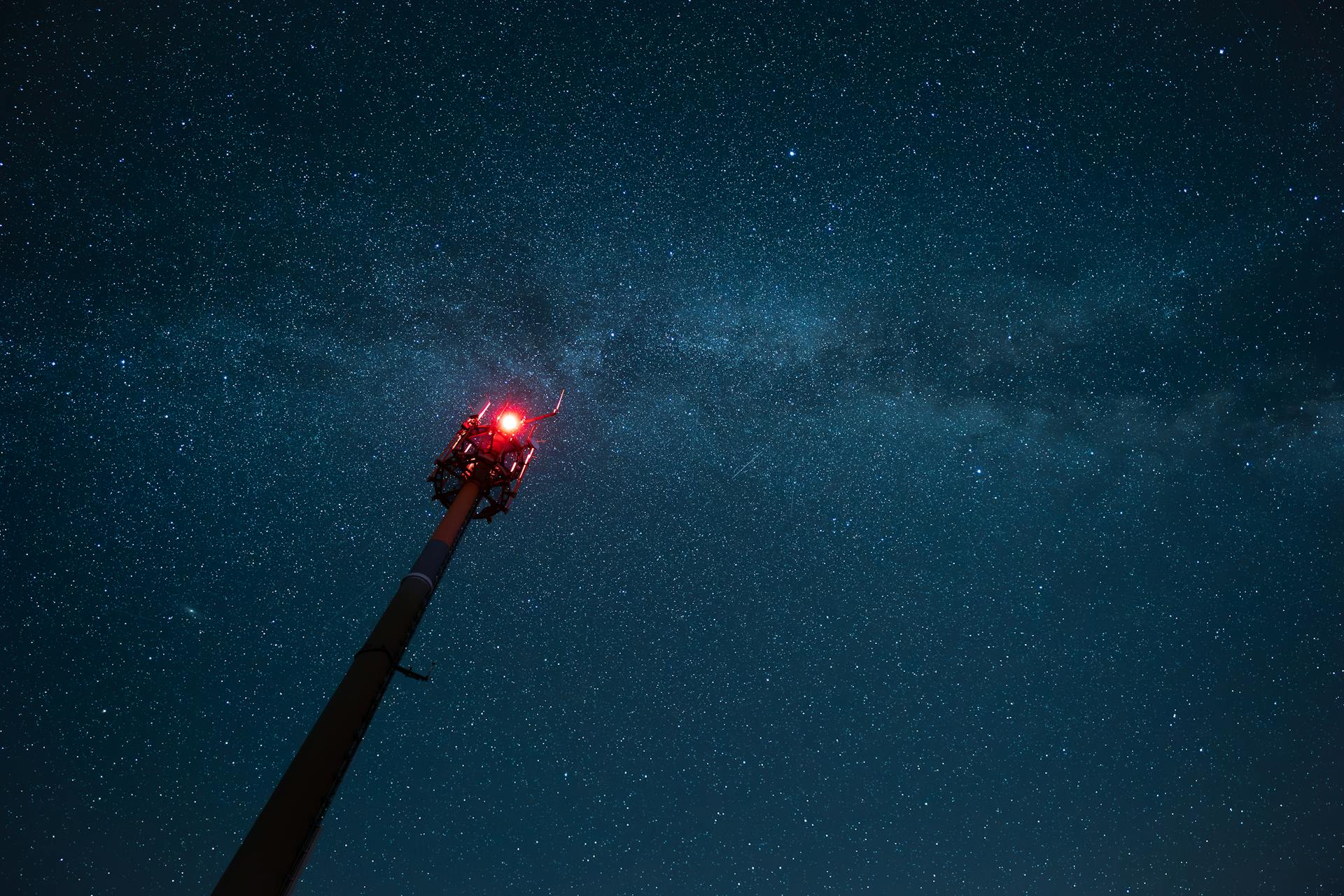 Relay Tower with Red Warning Light Against the Night Sky
