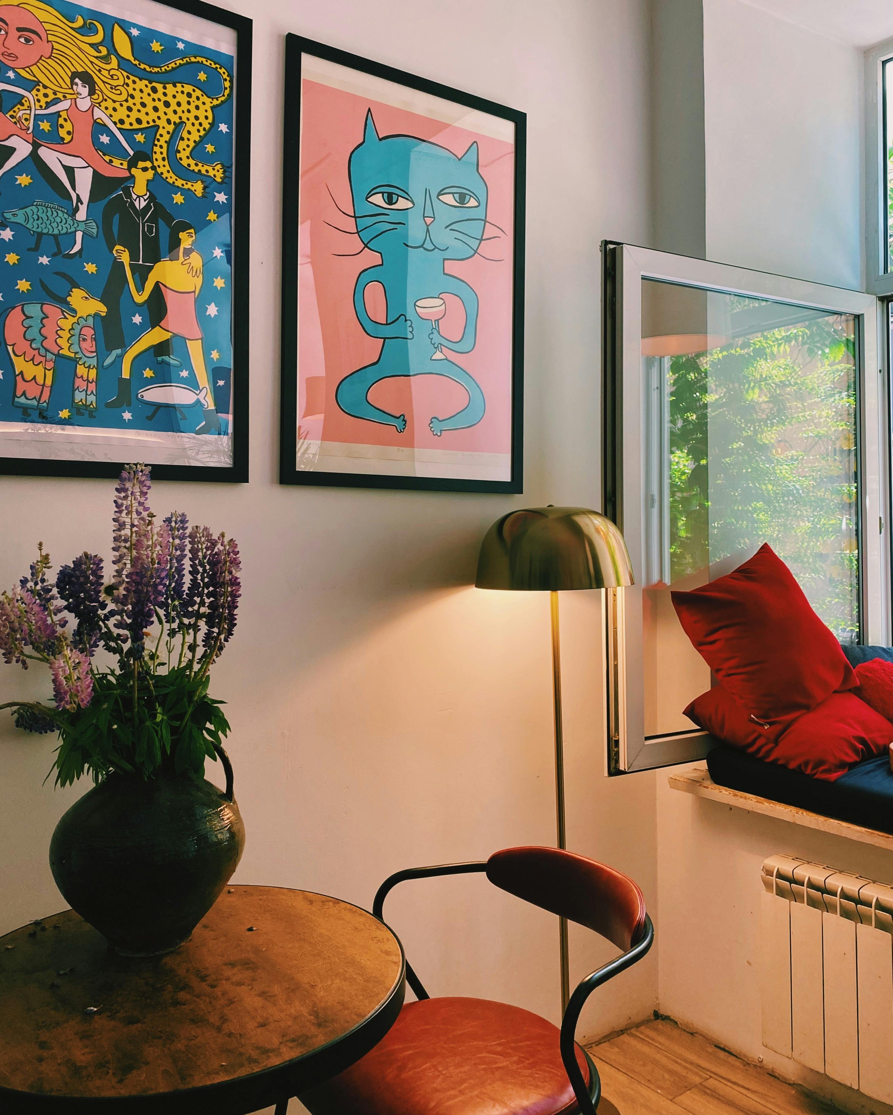 Cozy interior with artistic decor, vibrant artwork, and natural light through an open window.