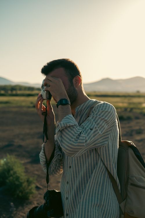 Free Man taking a photo with an analog camera during sunset in Kayseri, Türkiye. Stock Photo