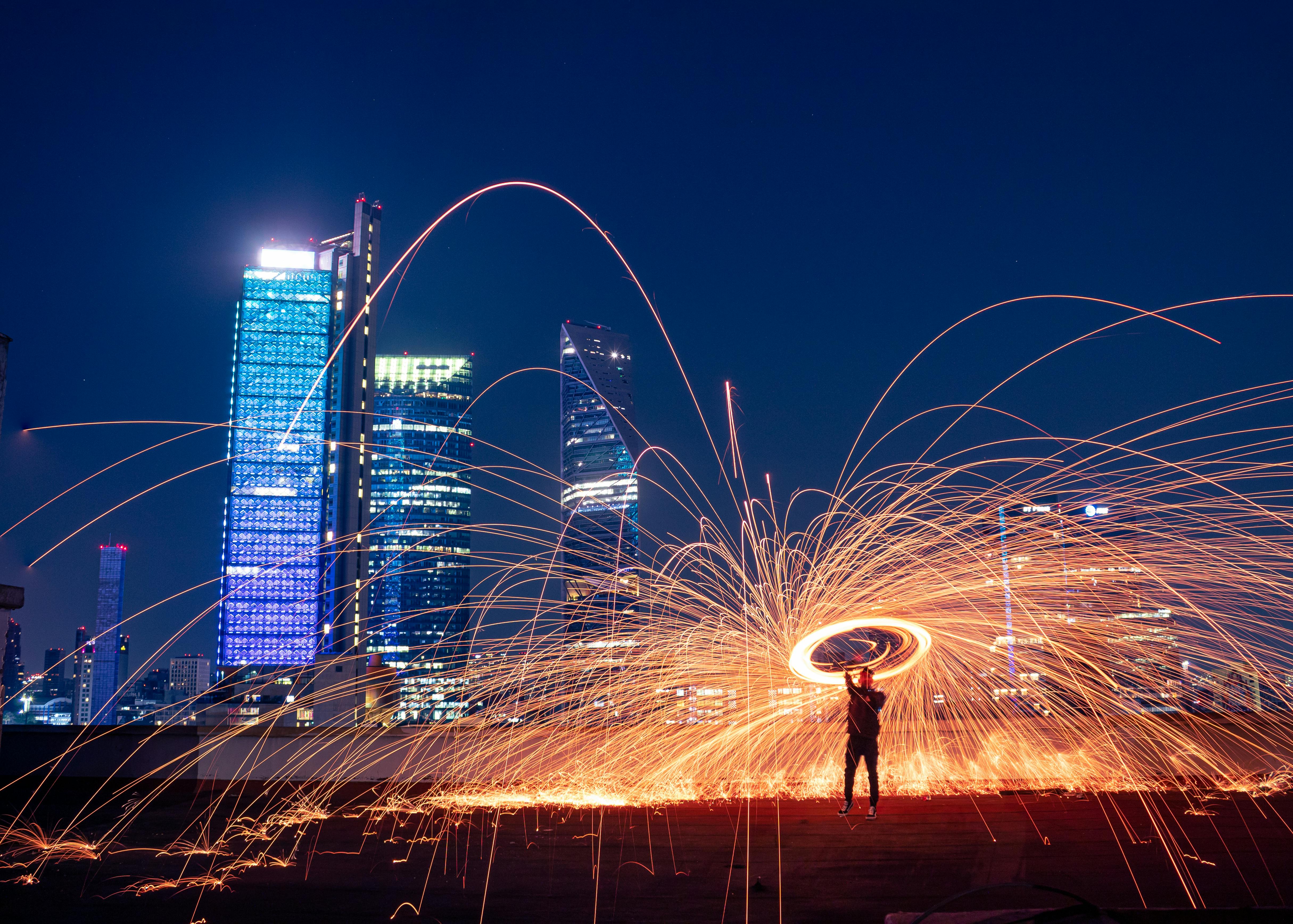 Vibrant steel wool photography against a panoramic night skyline in CDMX, Mexico.