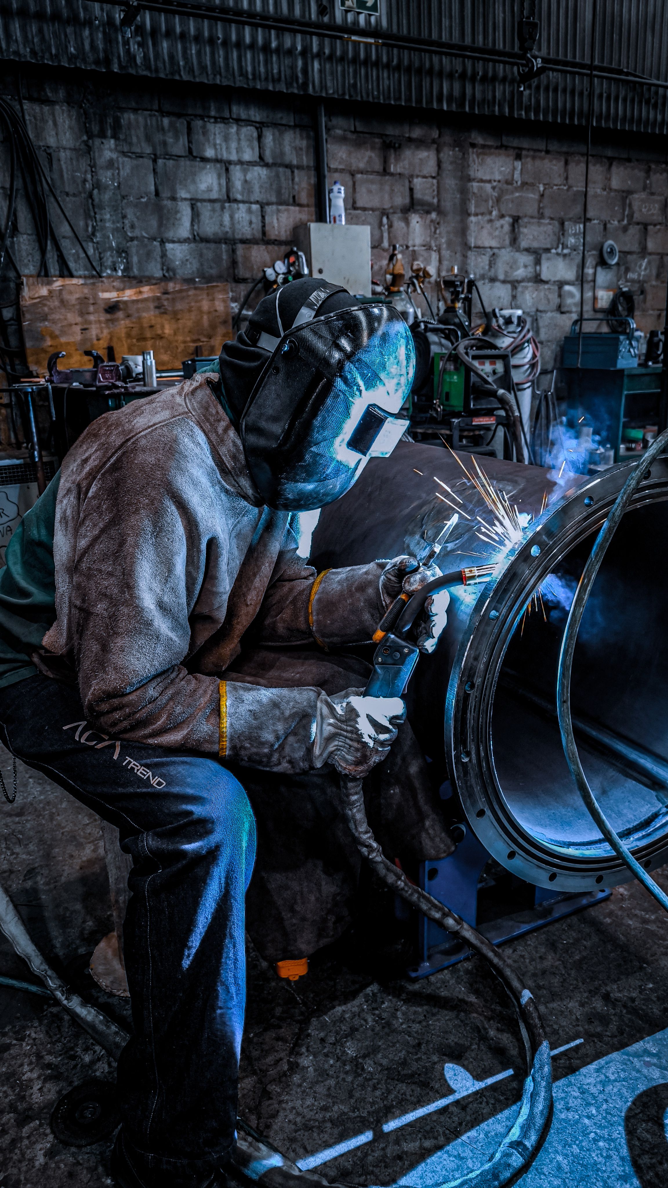 Soldador trabajando en taller industrial