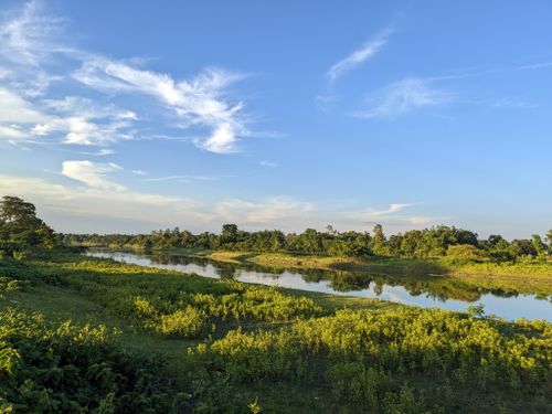 Free Idyllic view of Indian countryside with river and lush greenery under a bright sky. Stock Photo