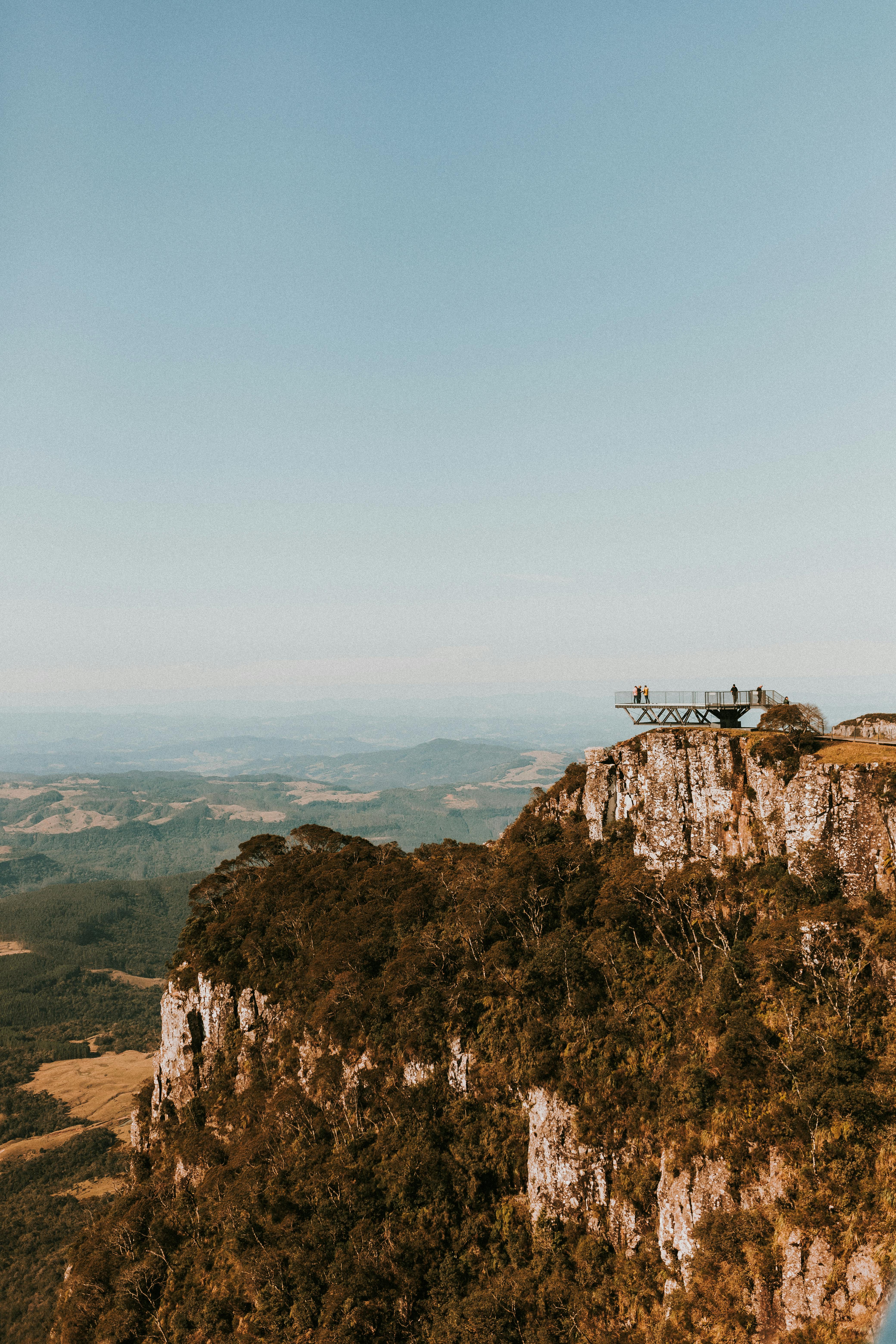 the view from the top of a cliff with a tree in the background