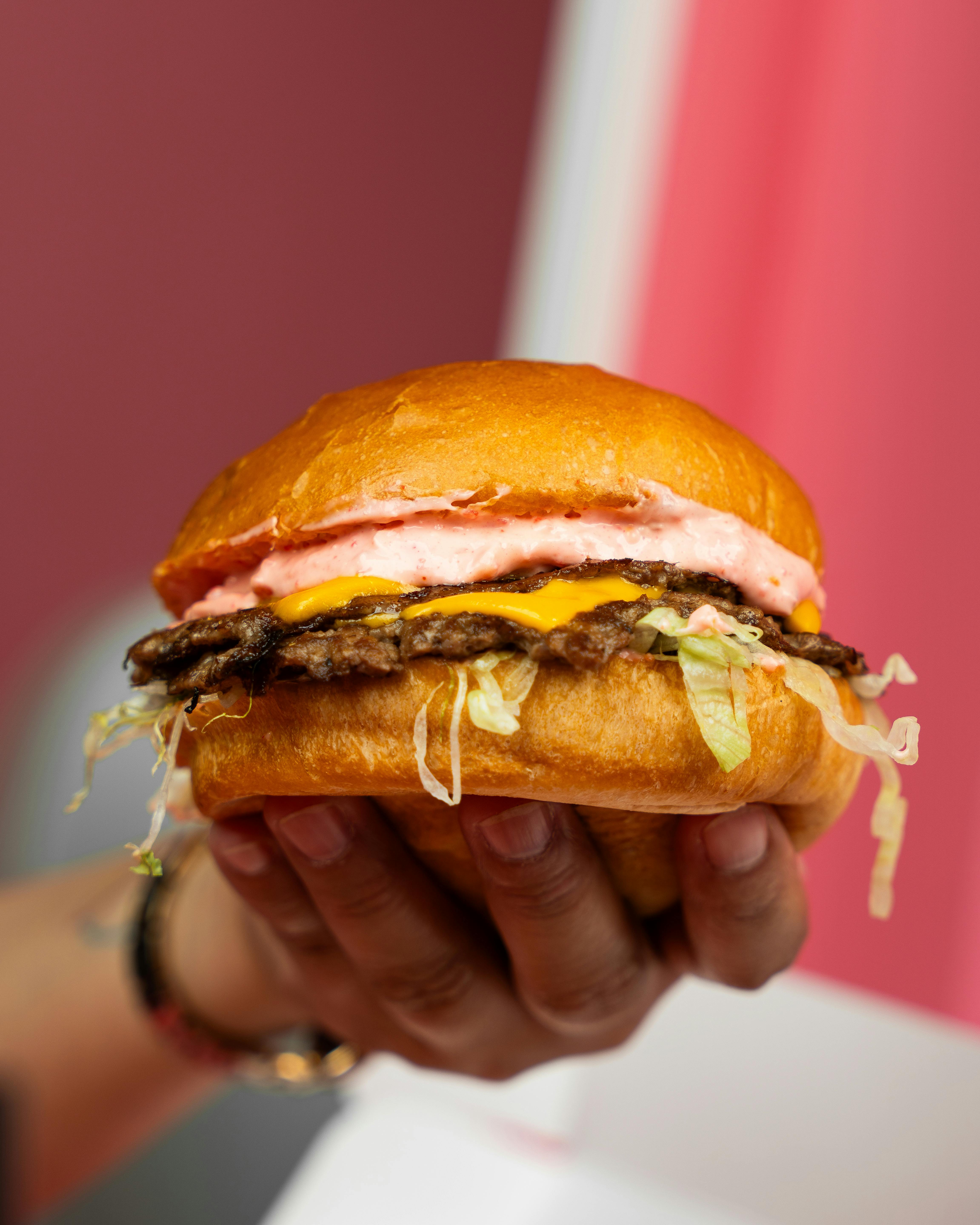 a person holding a hamburger in their hand