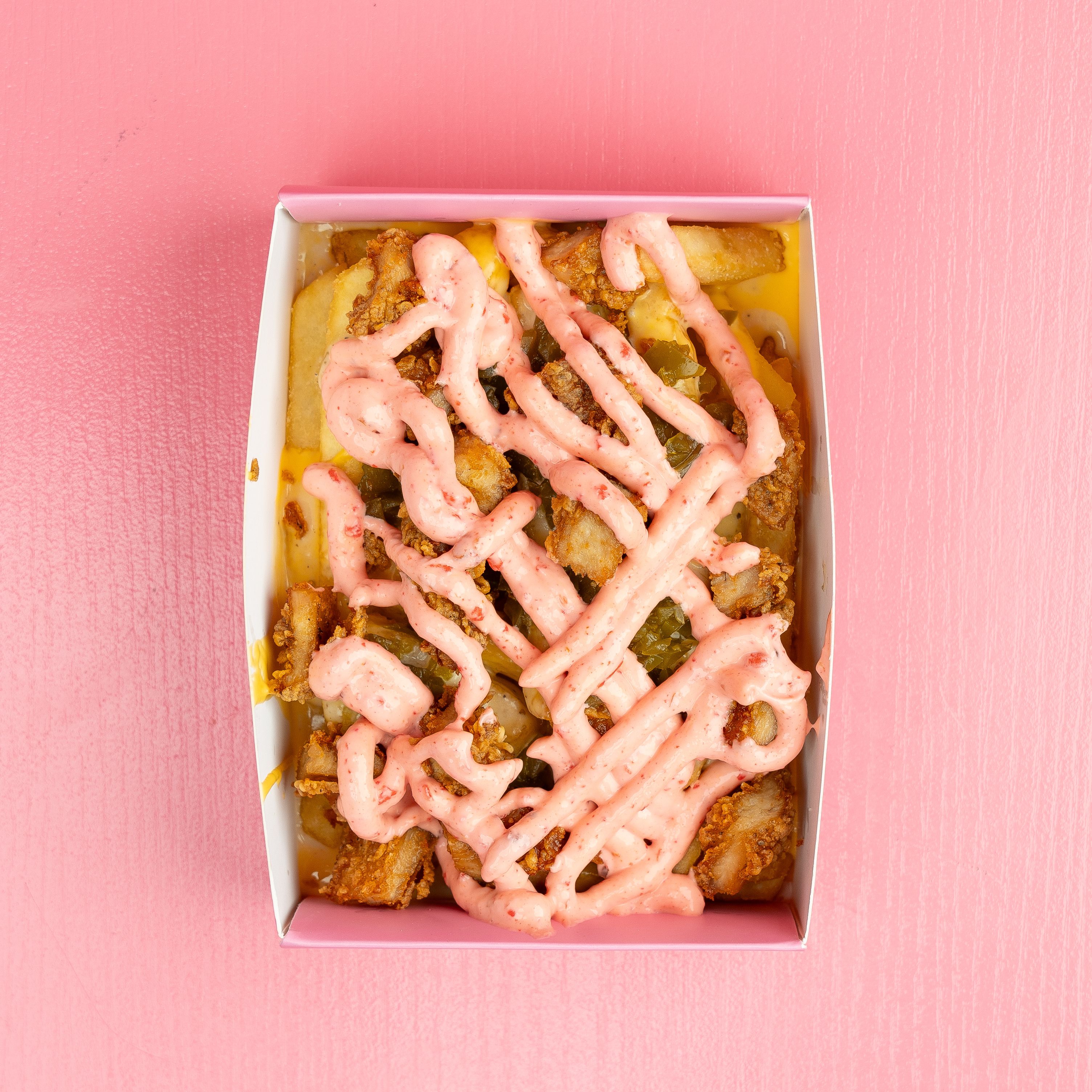 A box of fries with sauce on top · Free Stock Photo