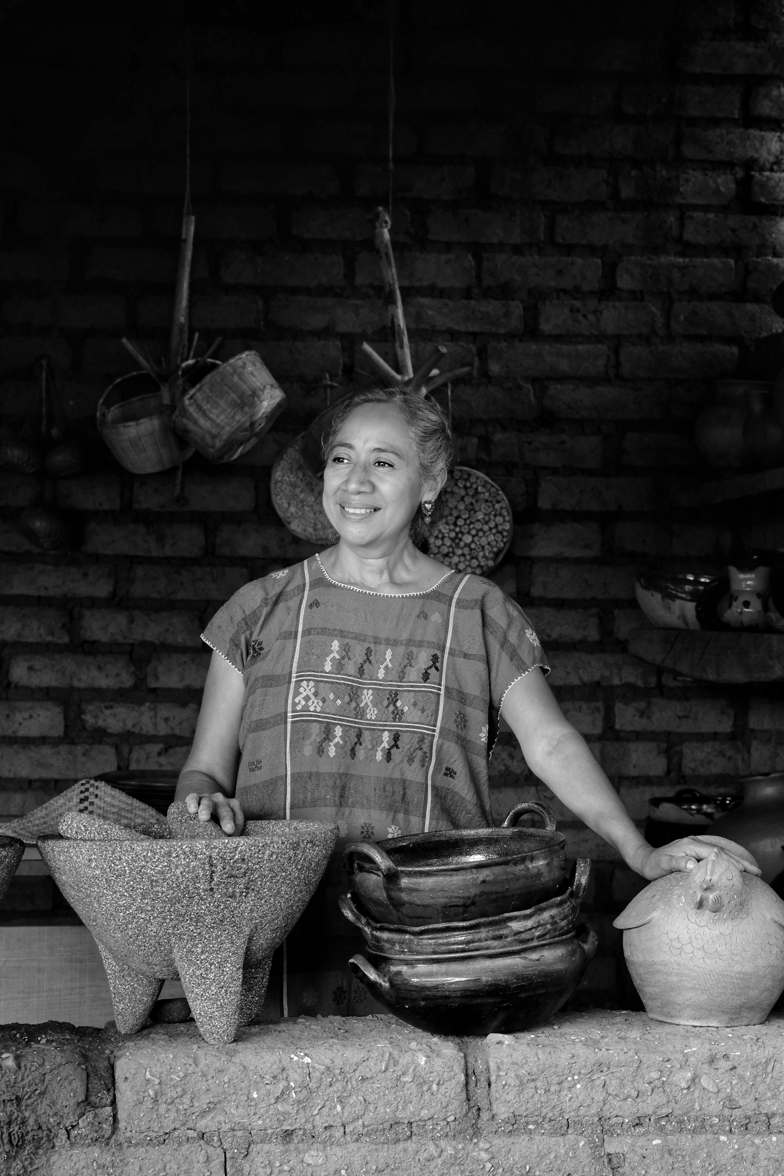 a woman is smiling while holding pots and bowls