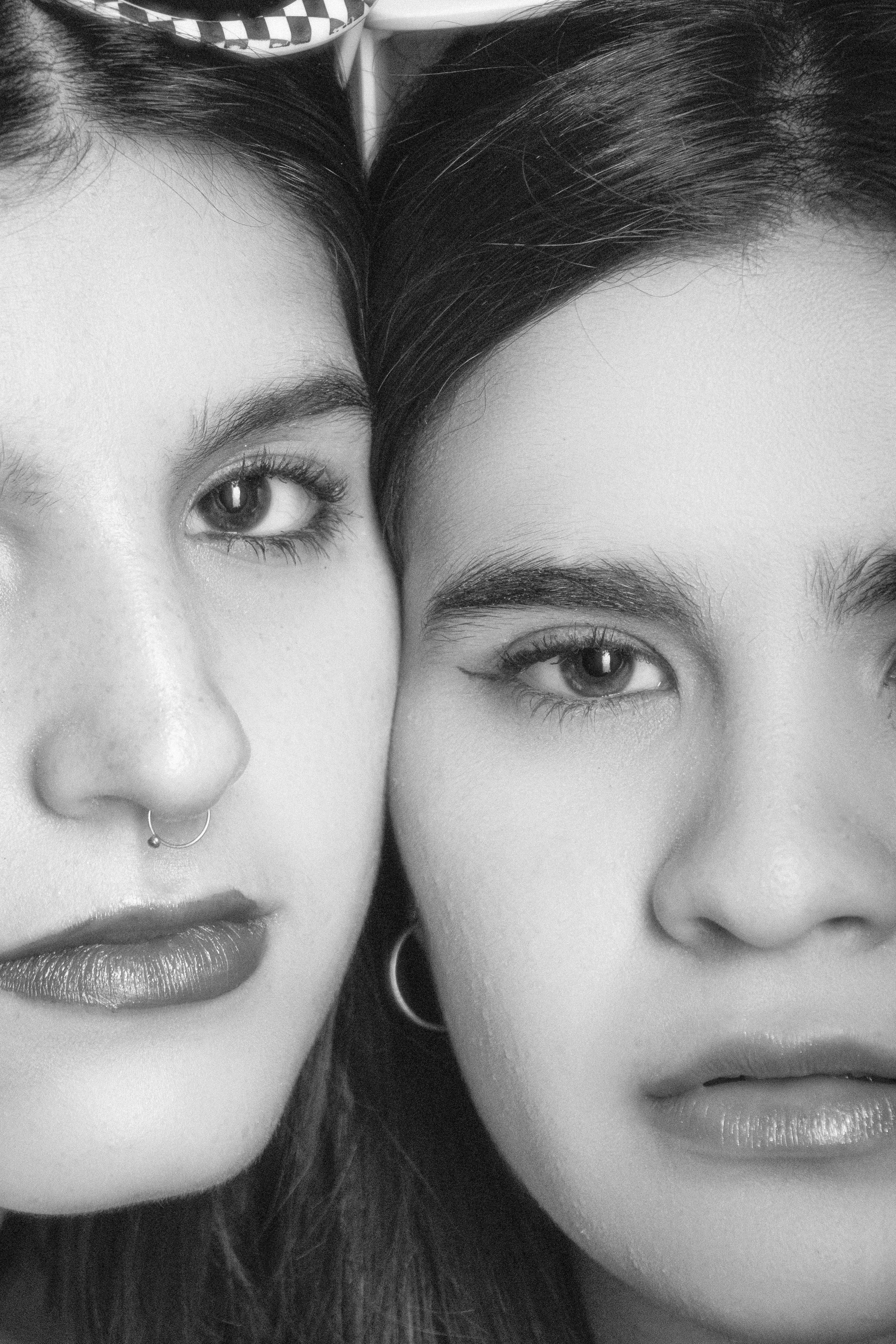 Artistic black and white portrait focusing on the facial expressions of two young women.