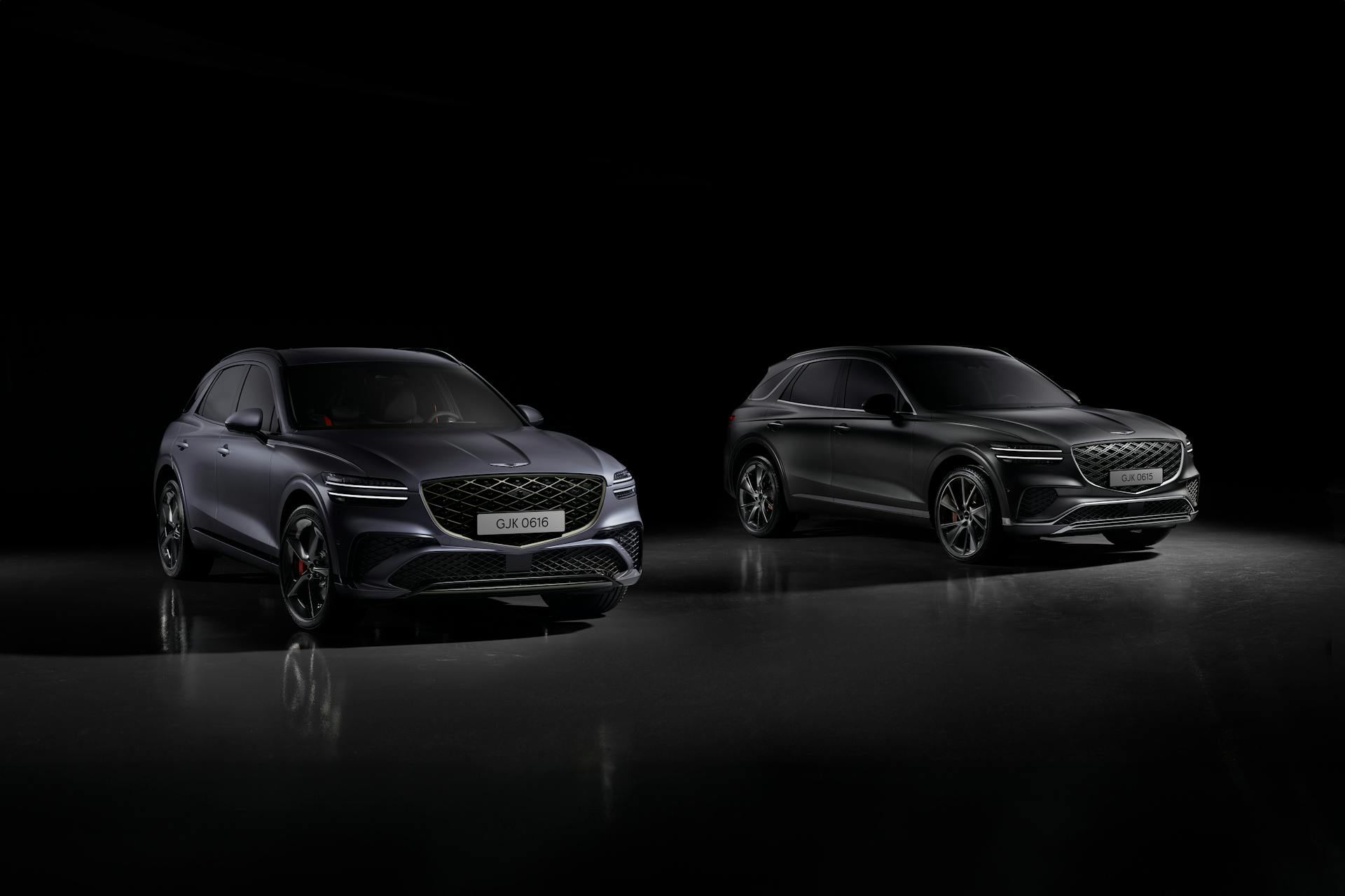 Two Genesis GV70 Sport SUVs showcased in a dramatic studio setting, highlighting luxury and design.