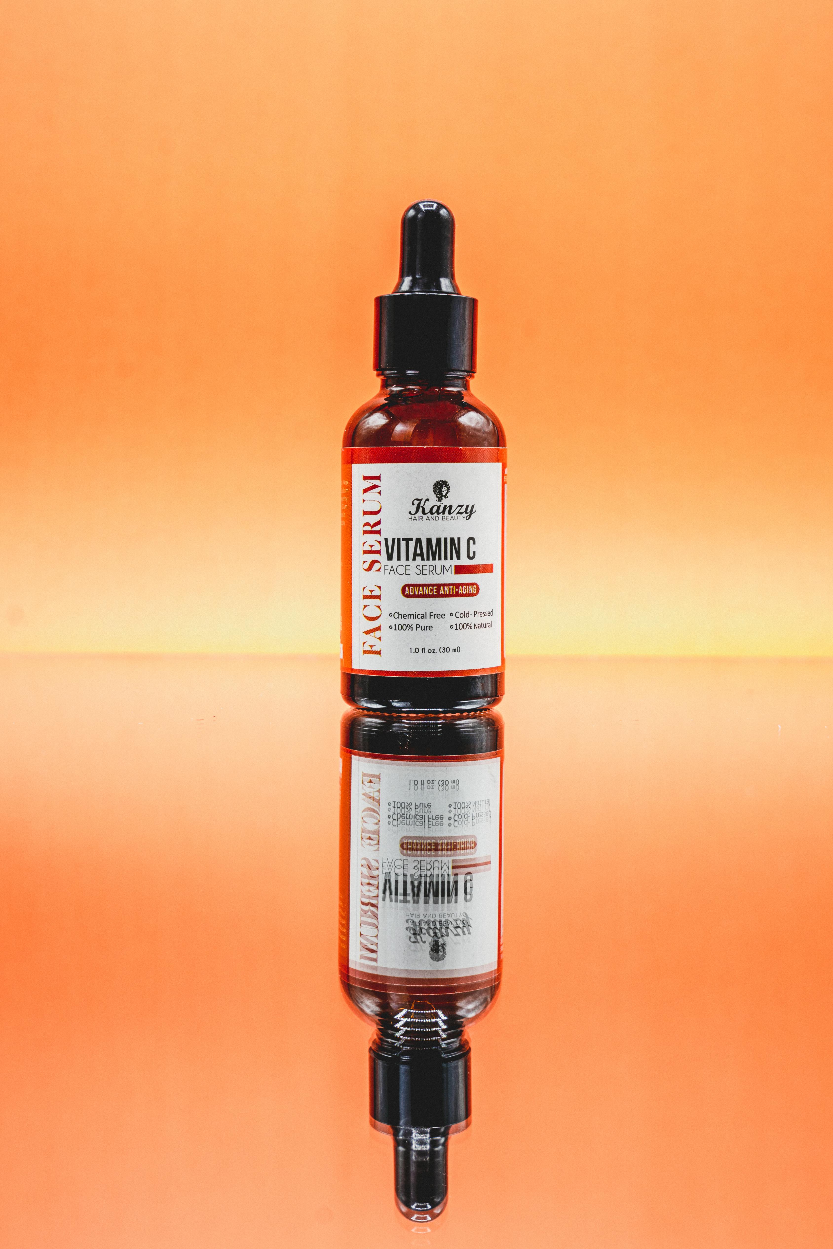 Bright and vibrant image of a Vitamin C face serum displayed on a reflective surface.
