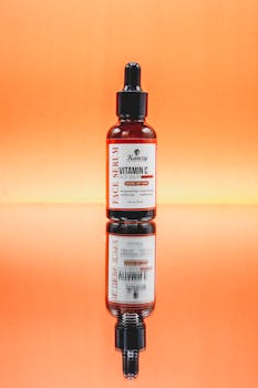 Bright and vibrant image of a Vitamin C face serum displayed on a reflective surface.