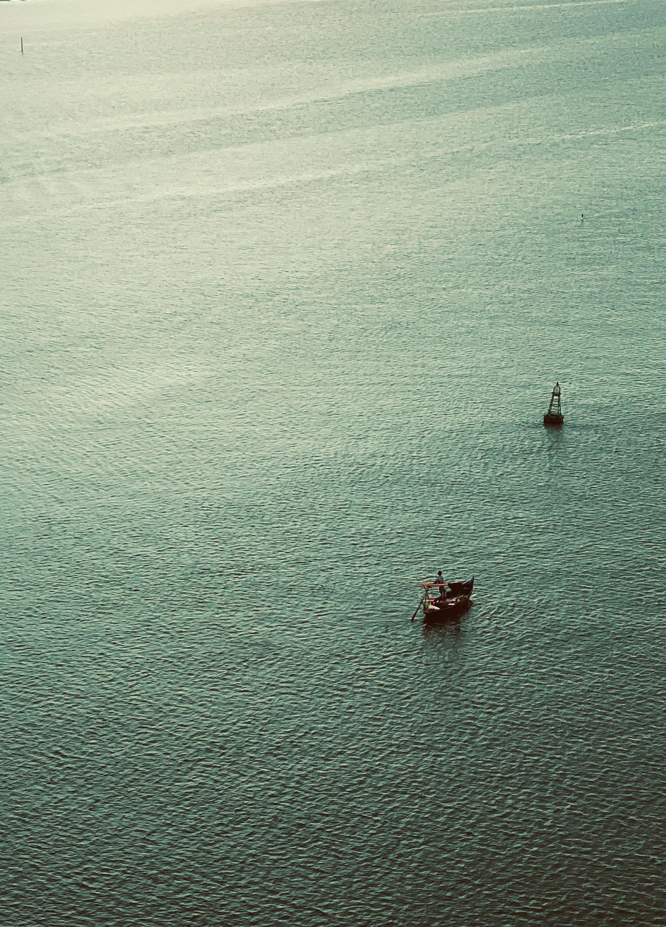 Peaceful scene of a fishing boat on calm waters near Hội An, Vietnam, captured in a tranquil setting.