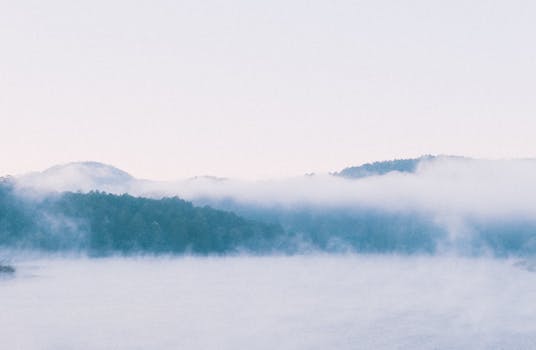 Serene view of mist over mountains and forest during a calm morning in Dalat, Vietnam.