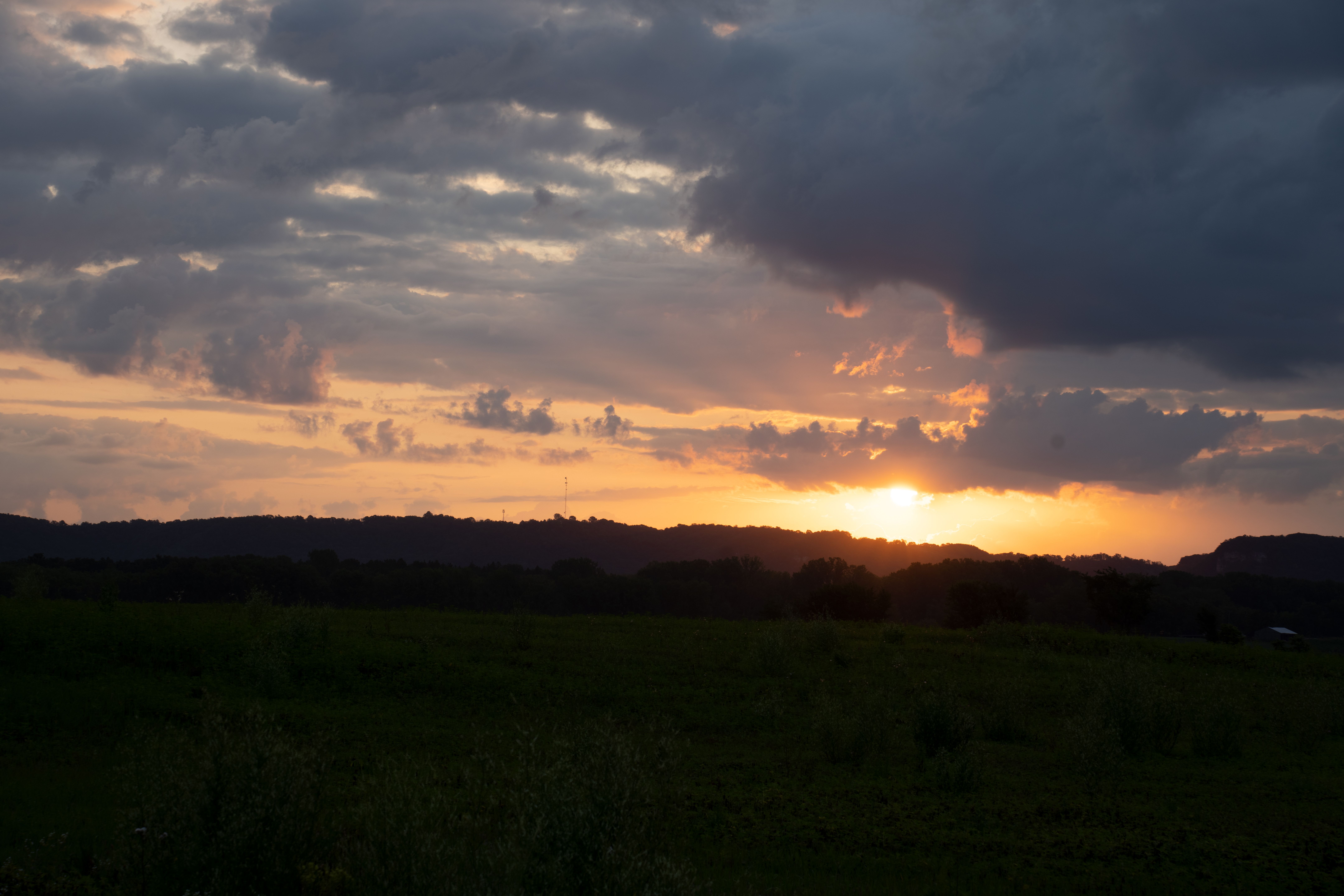 Majestic sunset over Kellogg, MN countryside with dramatic clouds and rolling hills.