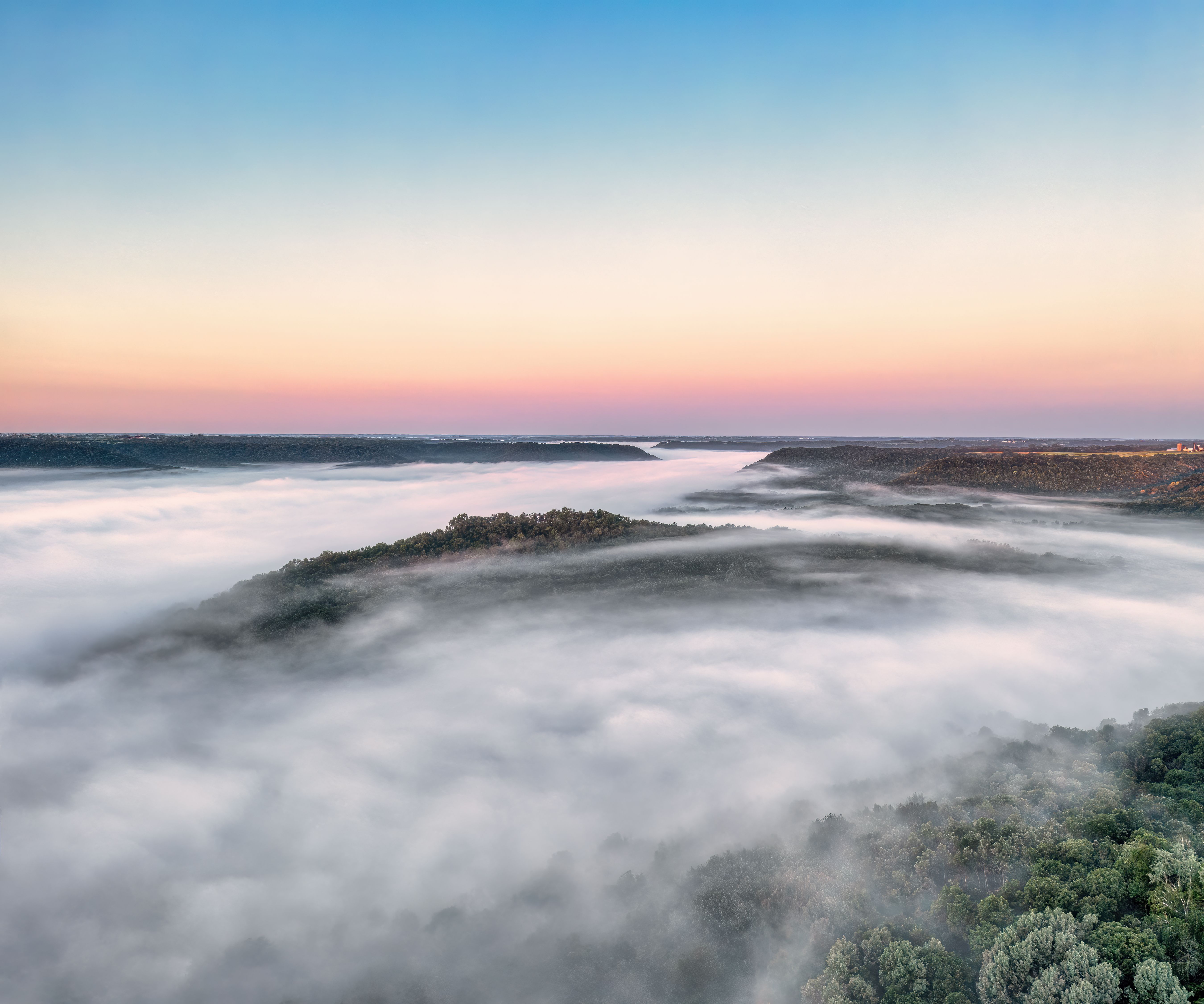 A breathtaking aerial shot of a misty landscape in Weaver, MN at dawn.