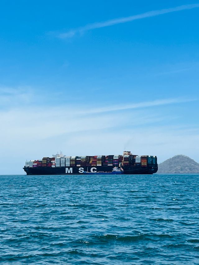 Large cargo ship carrying containers under a clear blue sky