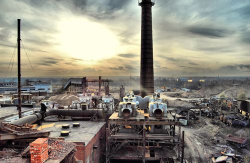 Free A deserted factory site with smokestack, captured at sunset, showcasing industrial decay. Stock Photo