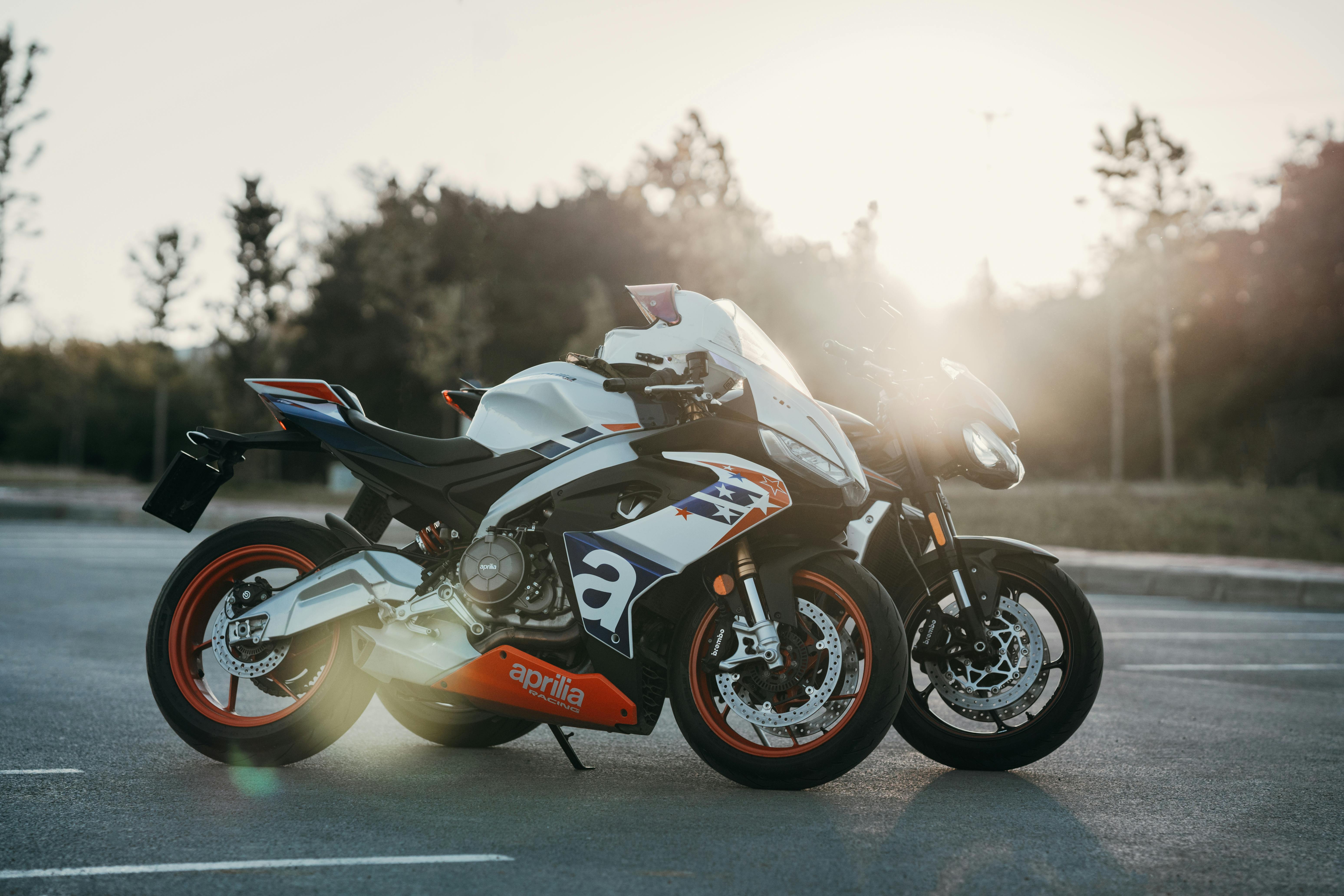 two motorcycles parked in the sun on a road