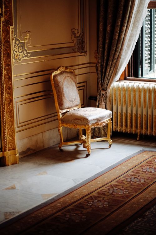 Free Elegant room in Ottoman style with a lavish gold-trimmed chair near a window. Stock Photo