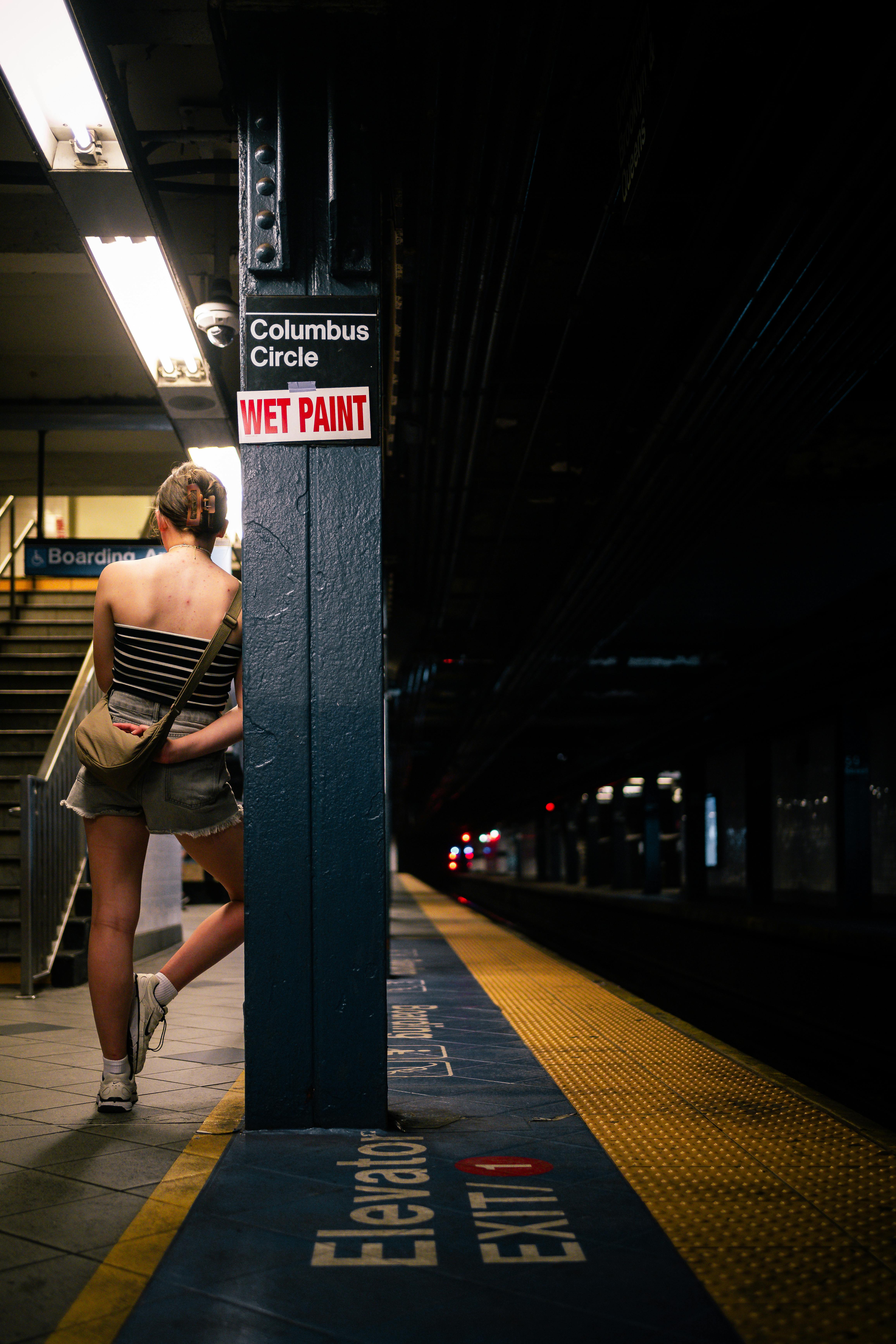 a woman standing at a subway station