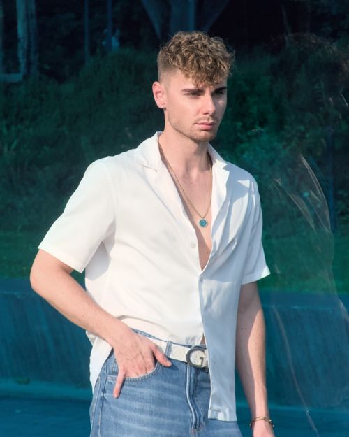 Free Portrait of a young man in a casual summer outfit standing outdoors in Berlin. Stock Photo