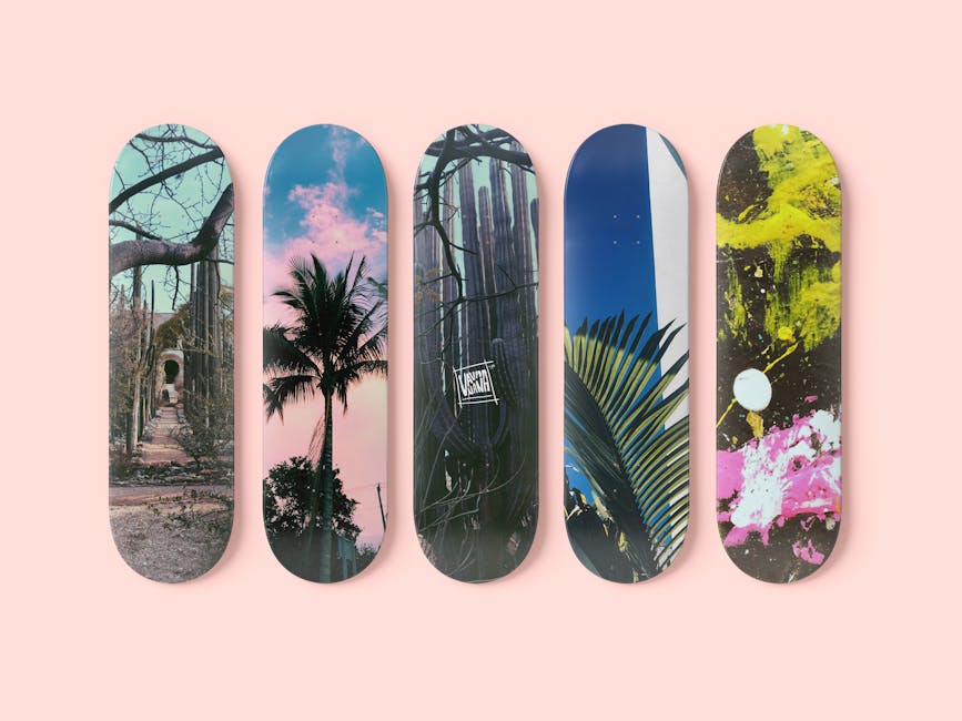 A collection of five vibrant skateboard decks with unique artistic designs and a pink background.