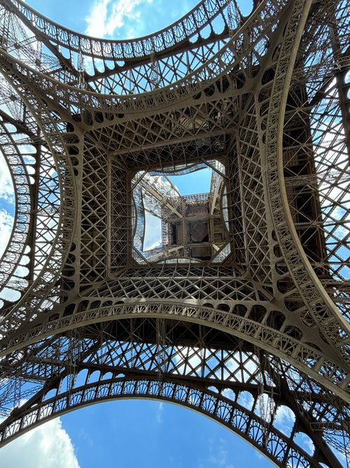 Free A striking view of the Eiffel Tower's iron lattice structure from beneath, showcasing Parisian architecture. Stock Photo